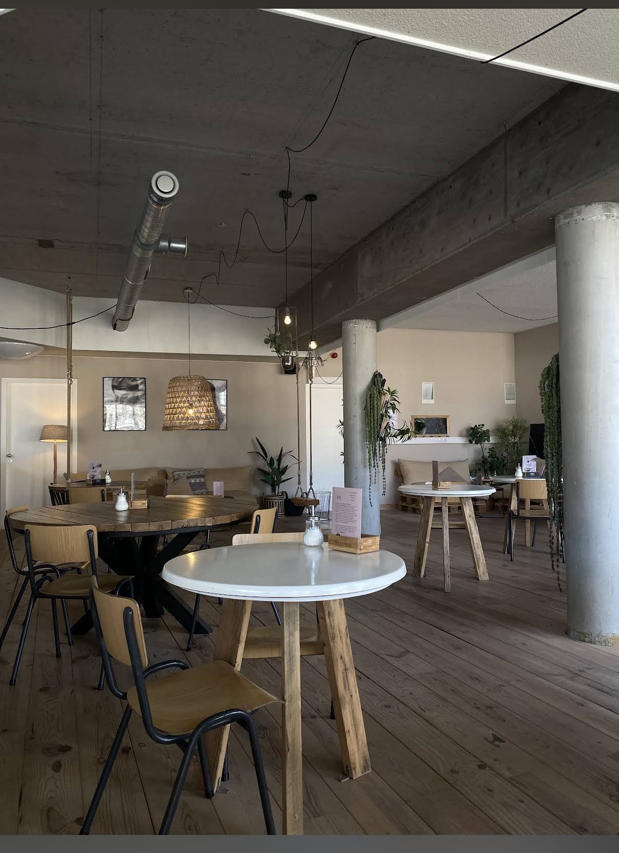 Licht, rustig interieur van Coffee Break met houten tafels en daglicht